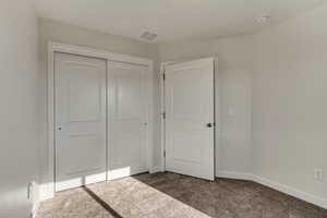 Unfurnished bedroom with a closet and carpet flooring