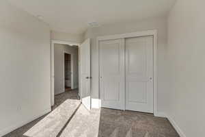 Unfurnished bedroom featuring carpet and a closet