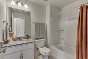 Full bathroom featuring vanity, shower / tub combo, and toilet