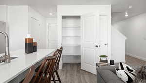 Home office featuring hardwood / wood-style flooring, built in desk, and a textured ceiling