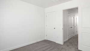 Unfurnished bedroom with dark carpet