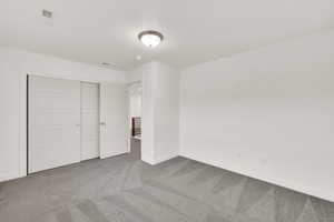 Unfurnished bedroom featuring carpet flooring, a closet, and a textured ceiling