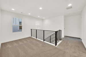 Empty room featuring light colored carpet