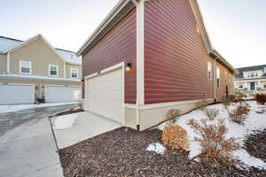 Snow covered property with central AC unit