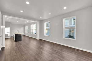 Unfurnished living room featuring sink and dark hardwood / wood-style flooring