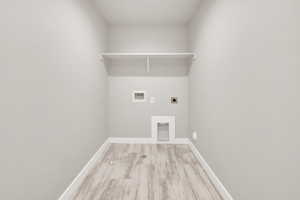 Clothes washing area featuring washer hookup, hookup for an electric dryer, and light hardwood / wood-style flooring