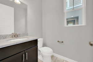 Bathroom featuring vanity, wood-type flooring, and toilet