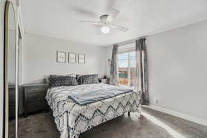 Carpeted bedroom with ceiling fan, a closet, and a textured ceiling