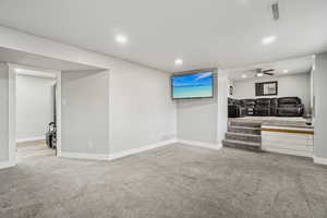 Carpeted living room featuring ceiling fan