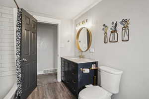 Full bathroom with hardwood / wood-style flooring, vanity, a textured ceiling, toilet, and shower / bath combo with shower curtain