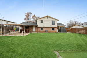 Back of house with cooling unit, a yard, and a patio area