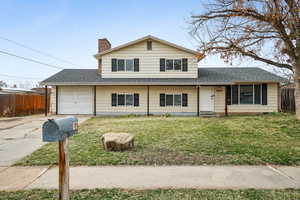 Front facade with a garage and a front lawn