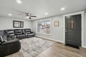 Living room featuring ceiling fan and wood-type flooring