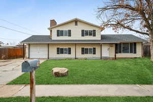 View of front of house with a garage and a front yard