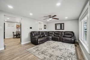 Living room with ceiling fan and light hardwood / wood-style floors