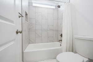 Bathroom featuring shower / bath combo and toilet