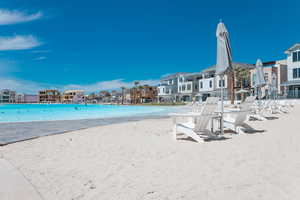 View of pool with a water view and a view of the beach