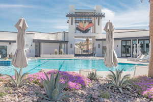 Back of house with a patio area and a community pool