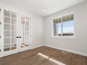 Empty room featuring french doors and wood-type flooring