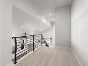 Hallway featuring lofted ceiling and carpet