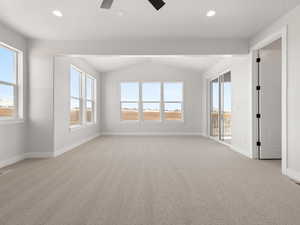 Unfurnished room featuring lofted ceiling, light colored carpet, and ceiling fan