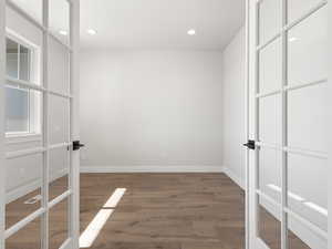 Spare room with dark hardwood / wood-style flooring and french doors