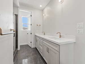Bathroom featuring vanity and a shower with shower door