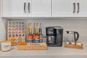 Room details featuring white cabinetry and light stone counters