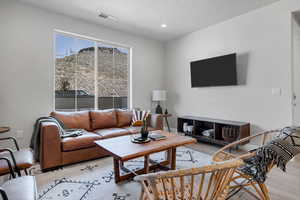 Living room with a textured ceiling and light wood-type flooring