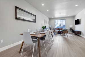 Dining area featuring light hardwood / wood-style floors and a textured ceiling