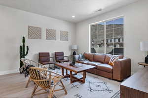 Living room with light hardwood / wood-style floors and a textured ceiling