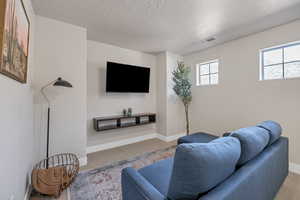 Carpeted living room with a textured ceiling