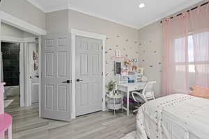 Bedroom with crown molding and light wood-type flooring