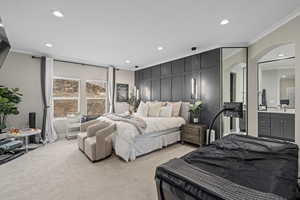 Bedroom featuring crown molding and light carpet