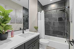 Full bathroom with shower / tub combo with curtain, vanity, and toilet