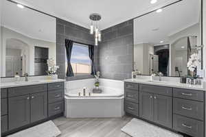 Bathroom featuring tile walls, hardwood / wood-style floors, vanity, and ornamental molding