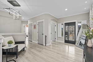 Interior space with ornamental molding and light wood-type flooring