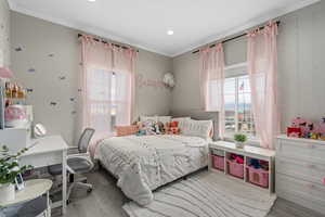 Bedroom with crown molding and light wood-type flooring