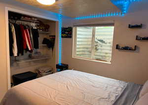 Bedroom featuring a textured ceiling and a closet