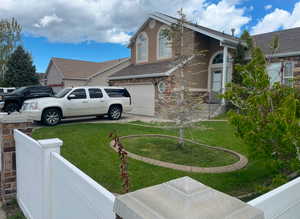 View of side of home featuring a garage and a yard