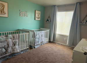 Bedroom with a crib and carpet