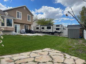 View of yard with a storage shed and a patio area