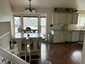 Dining room with an inviting chandelier, dark hardwood / wood-style floors, and sink