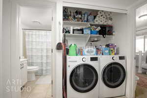 Laundry room with washer and dryer and light tile patterned floors