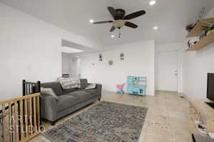 Living room featuring light tile patterned floors and ceiling fan