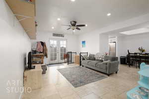 Living room with ceiling fan, a textured ceiling, and french doors