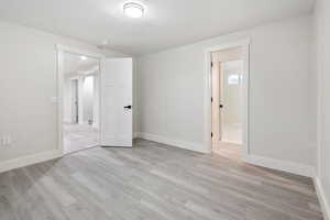 Spare room with a textured ceiling and light hardwood / wood-style floors