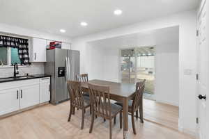 Dining space with sink and light hardwood / wood-style flooring