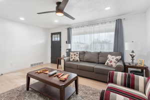 Living room featuring ceiling fan and light wood-type flooring