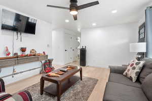 Living room with ceiling fan and light hardwood / wood-style floors